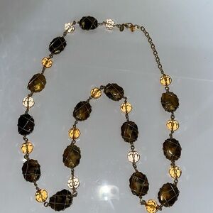 Long necklace amber looking pieces strung with gold color wire.